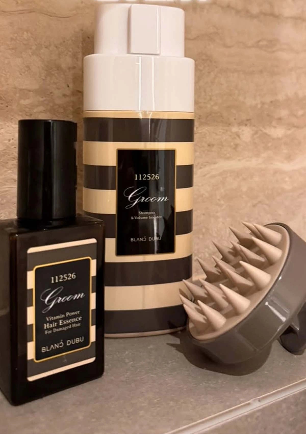 Two hair care products with striped design on a textured surface